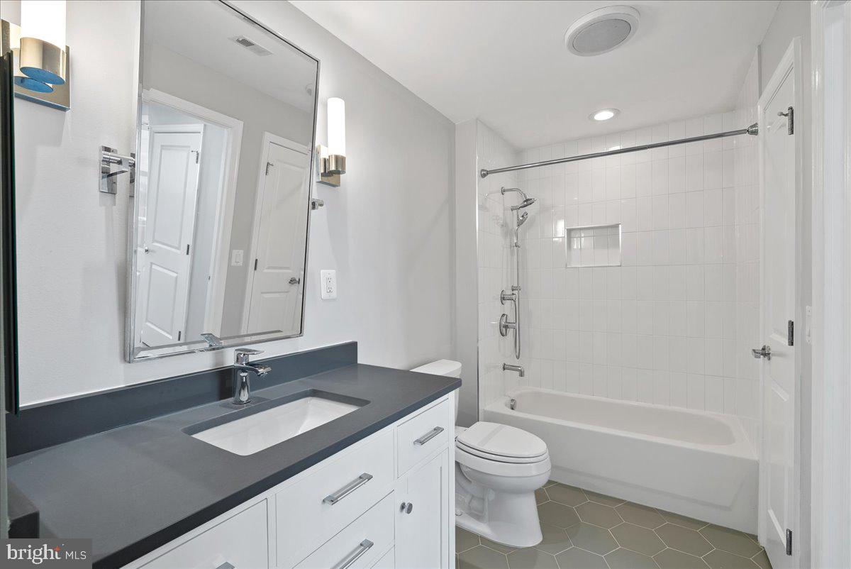 11760 Sunrise Valley Drive, Unit 909 Reston, VA 20191 - Photo 16 of 20 a bathroom with a granite countertop sink toilet and shower