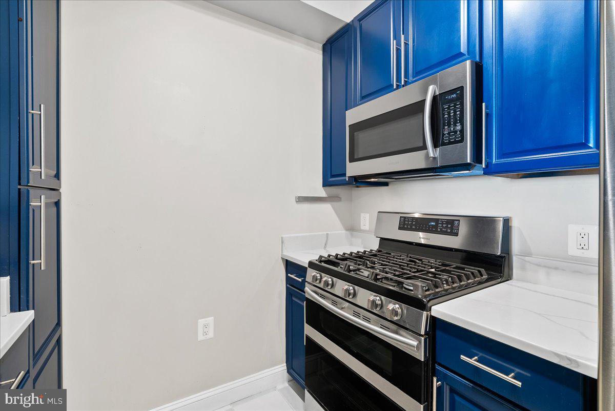11760 Sunrise Valley Drive, Unit 909 Reston, VA 20191 - Photo 4 of 20 a kitchen with a stove and a microwave