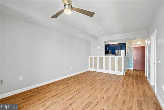 a view of a room with wooden floor and a ceiling fan