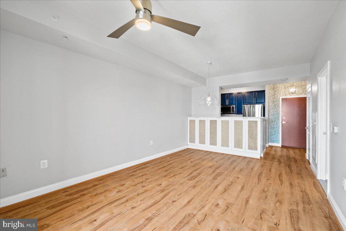 11760 Sunrise Valley Drive, Unit 909 Reston, VA 20191 - Photo 10 of 20 a view of a room with wooden floor and a ceiling fan