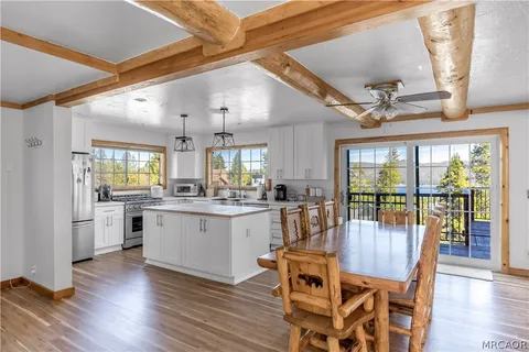a dining room with wooden floor and large window