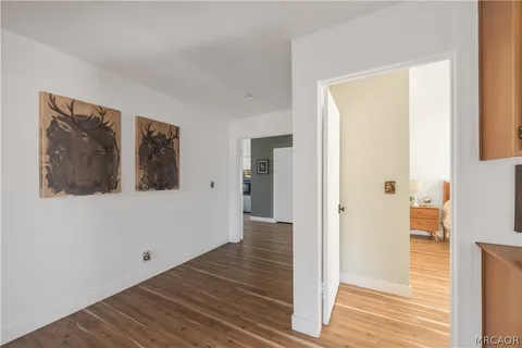 a view of a hallway with wooden floor and entryway