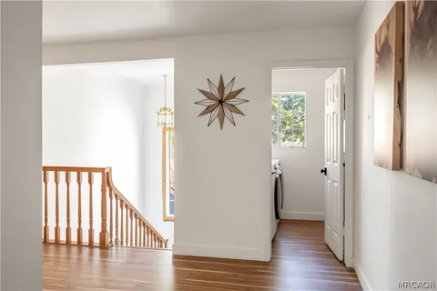 a view of a hallway with wooden floor and closet