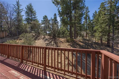 a view of balcony with wooden floor and fence