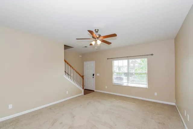 an empty room with window and ceiling fan