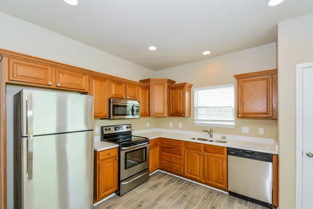 a kitchen with stainless steel appliances granite countertop a refrigerator sink and microwave