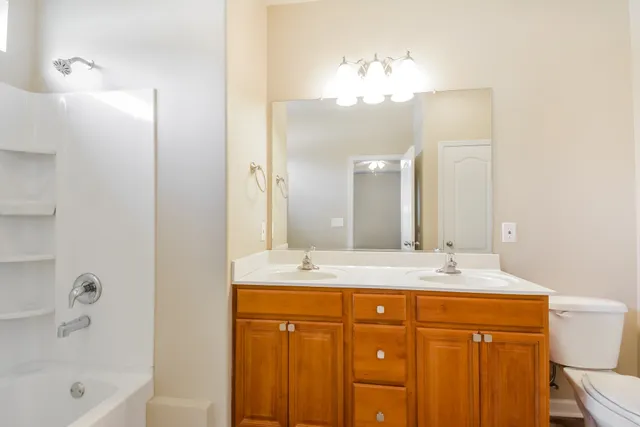a bathroom with a sink vanity granite tub and a mirror