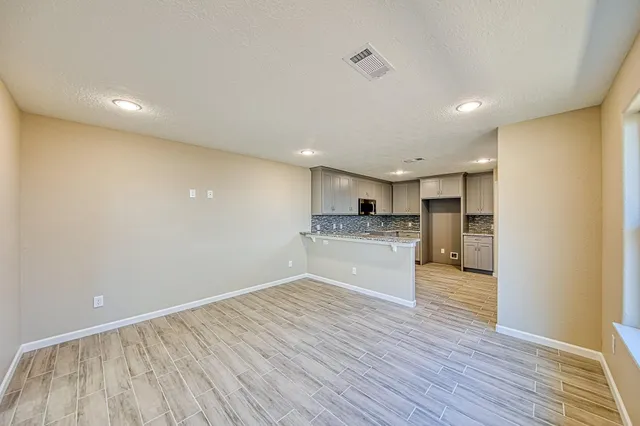 a view of kitchen electric appliances wooden floor and cabinets