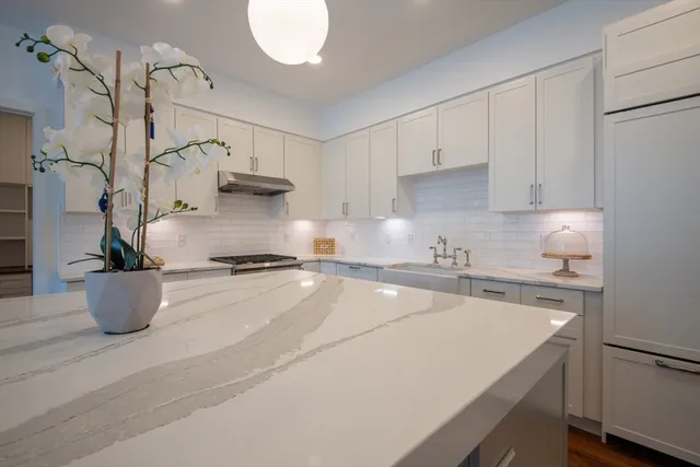 a kitchen with a stove and white cabinets