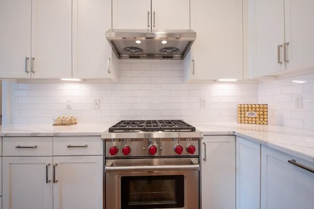 a stove top oven sitting inside of a kitchen