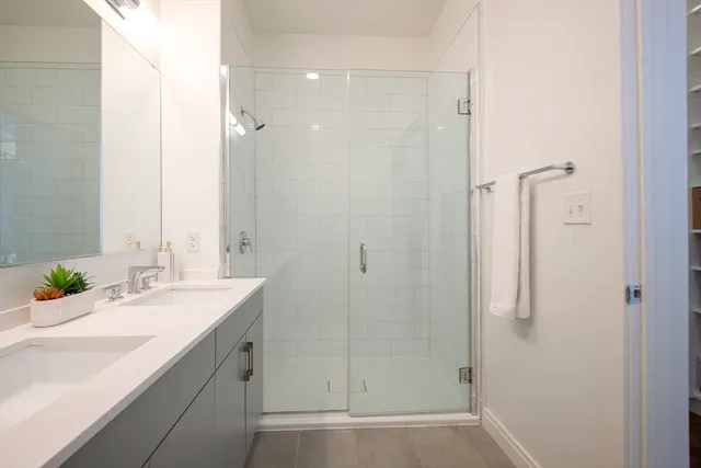 a bathroom with a shower sink and mirror