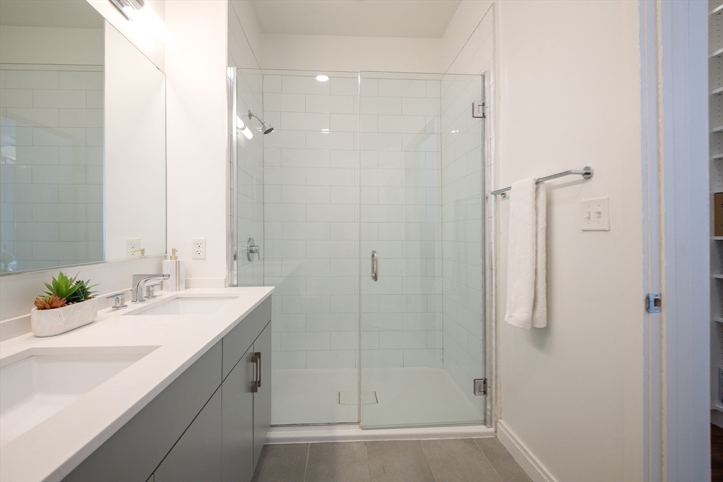 3531 Washington Street, Unit 316 Boston, MA 02130 - Photo 20 of 40 a bathroom with a shower sink and mirror