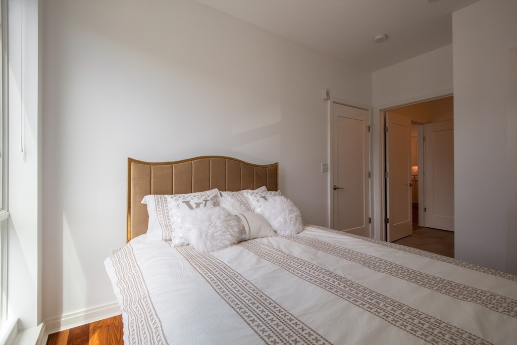 3531 Washington Street, Unit 316 Boston, MA 02130 - Photo 24 of 40 a bedroom with a bed and a night stand