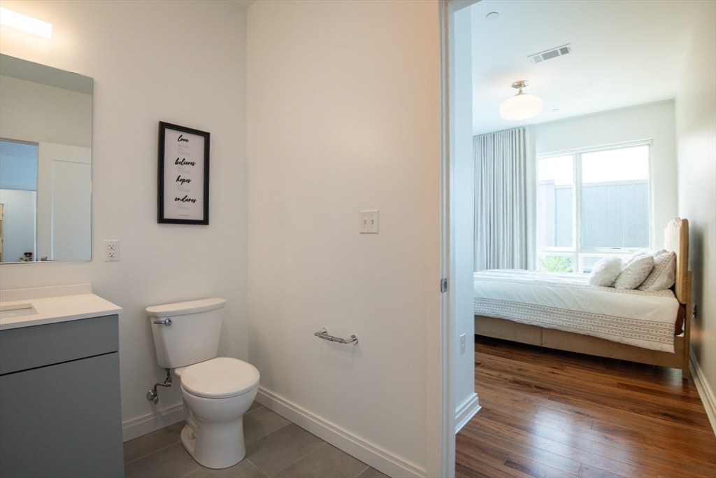 3531 Washington Street, Unit 316 Boston, MA 02130 - Photo 26 of 40 a bathroom with a toilet sink and a mirror