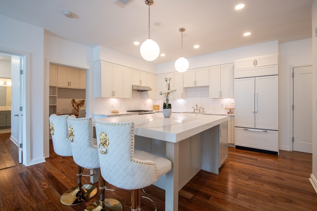 3531 Washington Street, Unit 316 Boston, MA 02130 - Photo 8 of 40 a kitchen with kitchen island a white cabinets and chairs