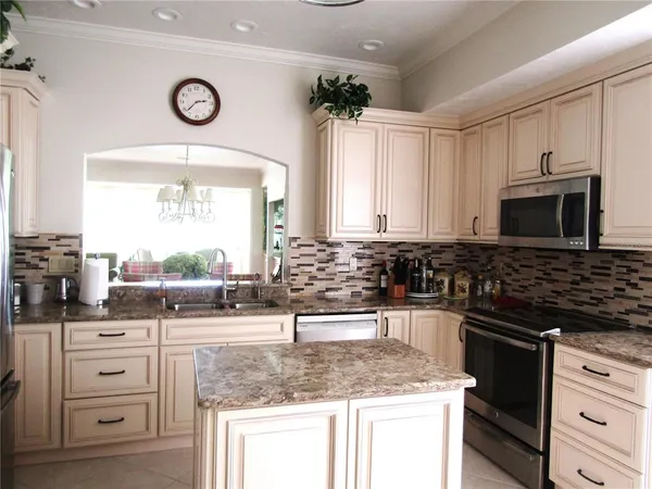 a kitchen with granite countertop a sink stove and microwave