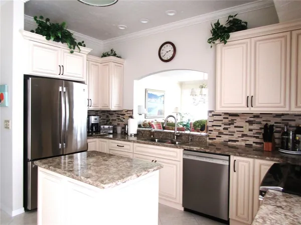 a kitchen with stainless steel appliances granite countertop a sink a stove and a refrigerator