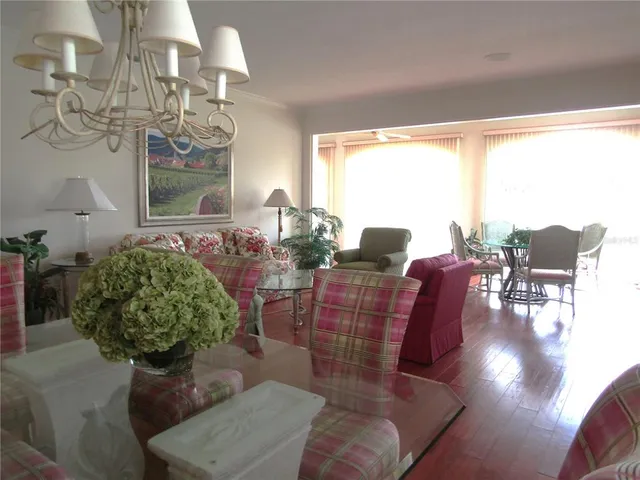 a living room with furniture chandelier and a large window