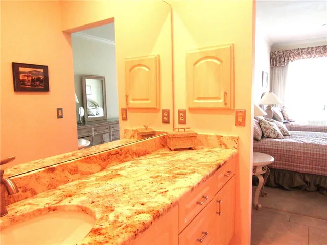 a spacious bathroom with a granite countertop sink and a bathtub