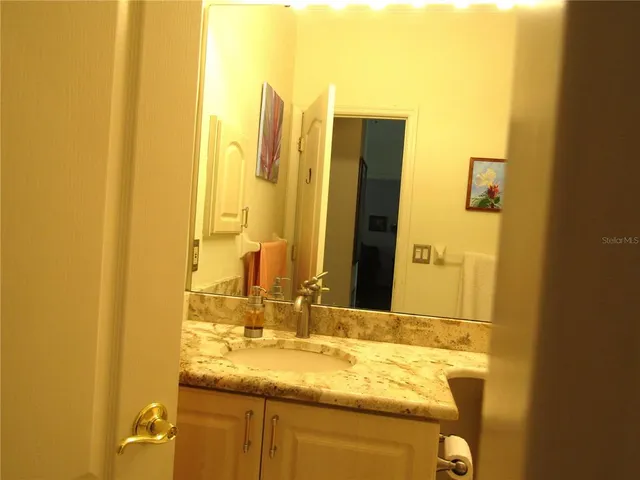 a bathroom with a granite countertop sink and a mirror