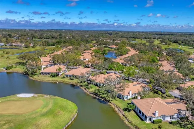 an aerial view of residential houses with outdoor space and lake view