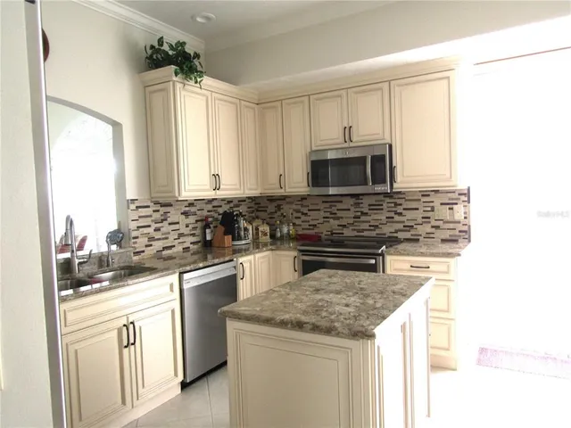 a kitchen with white cabinets and appliances