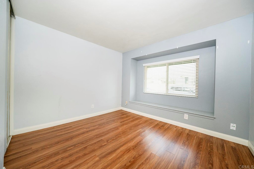 249 Fredricks Avenue Oceanside, CA 92058 - Photo 17 of 31 a view of an empty room with wooden floor and a window
