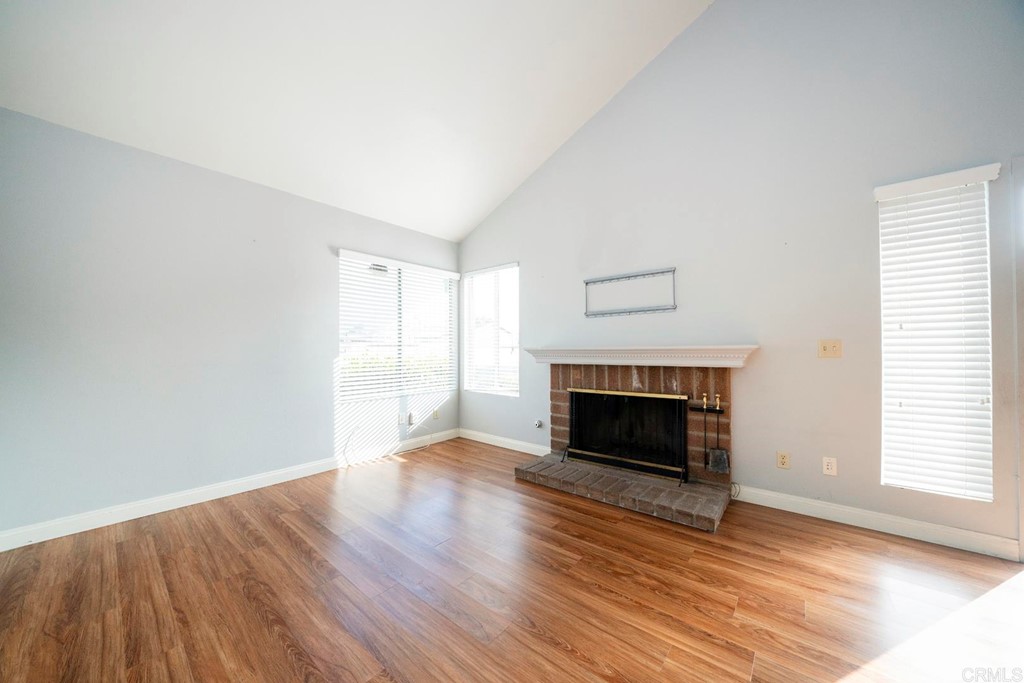 249 Fredricks Avenue Oceanside, CA 92058 - Photo 5 of 31 an empty room with wooden floor fireplace and windows