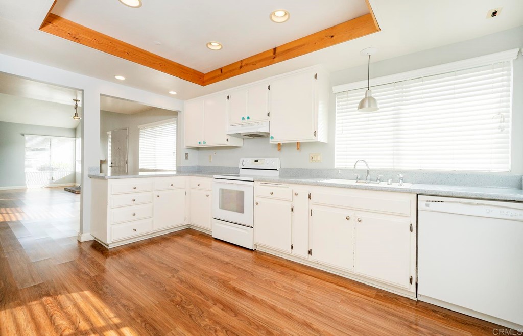 249 Fredricks Avenue Oceanside, CA 92058 - Photo 7 of 31 a large white kitchen with cabinets