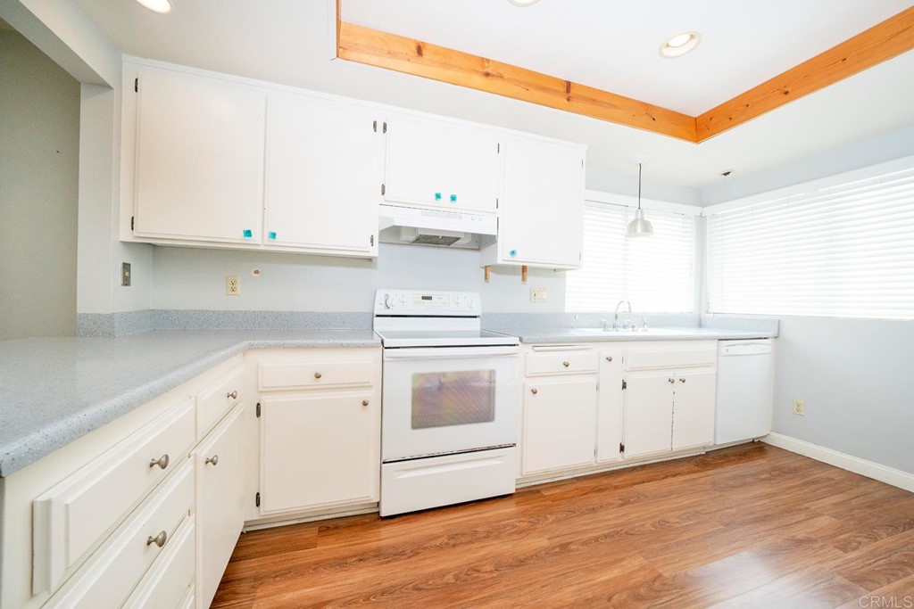 249 Fredricks Avenue Oceanside, CA 92058 - Photo 8 of 31 a kitchen with granite countertop white cabinets white stainless steel appliances with a sink and dishwasher
