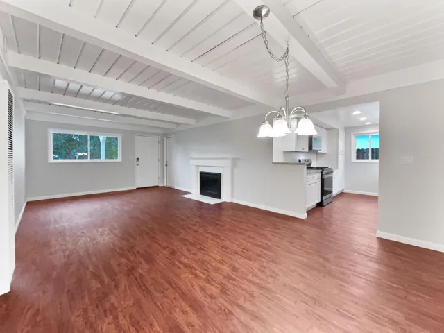 a view of a kitchen with a stove wooden floor and a chandelier