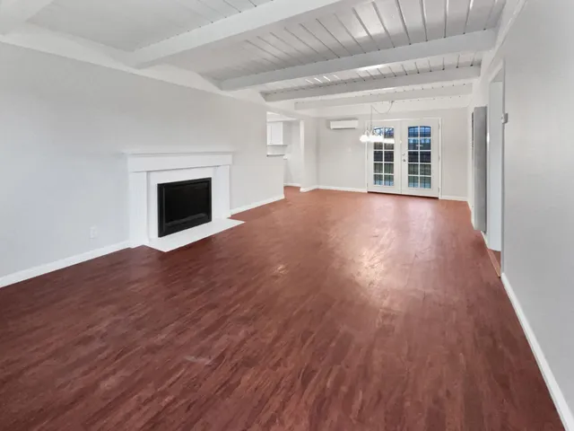 a view of empty room with wooden floor and fireplace