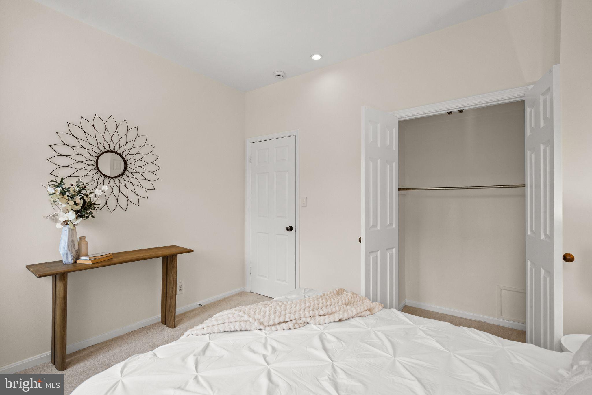 1008 Paper Mill Court, Unit 1008 Washington, DC 20007 - Photo 12 of 31 a bedroom with a bed and a chandelier