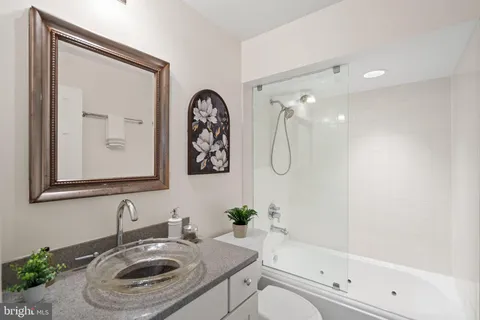 a bathroom with a granite countertop sink a toilet and shower