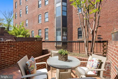 a view of a patio with couches table and chairs and potted plants