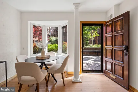 a dining room with furniture a rug wooden floor and a window
