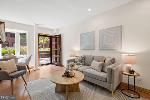 a living room with furniture a rug and a lamp
