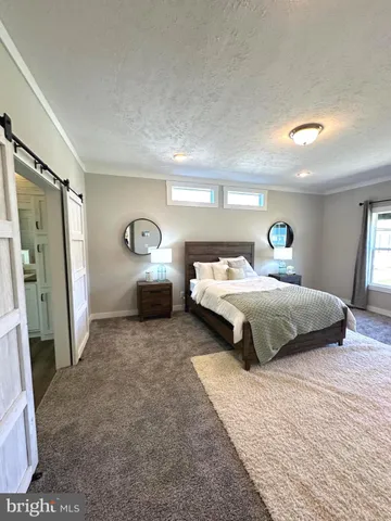 a spacious bedroom with a bed and a large window