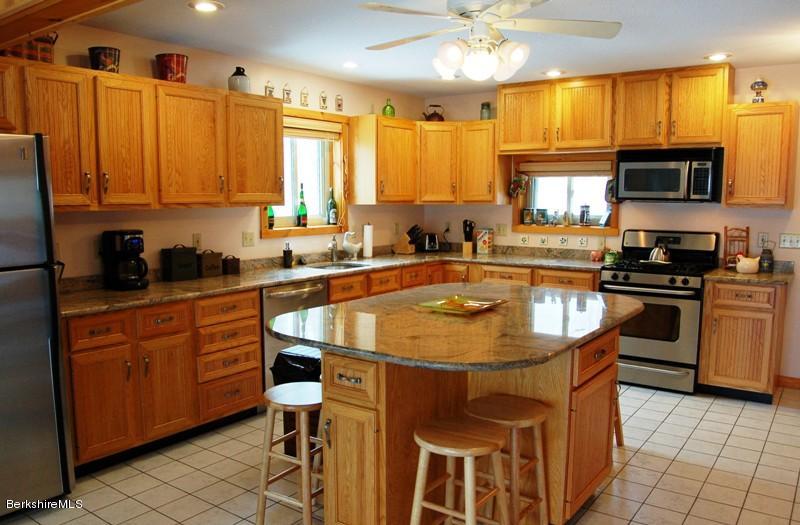 216 Dimmock Road Otis, MA 01253 - Photo 3 of 18 a kitchen with stainless steel appliances granite countertop a sink a stove and cabinets