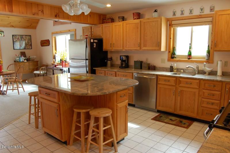 216 Dimmock Road Otis, MA 01253 - Photo 4 of 18 a kitchen with sink a refrigerator and chairs