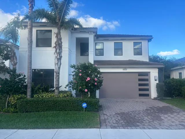a front view of a house with a yard and a garage