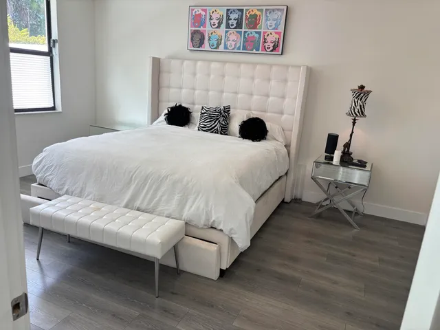 a bedroom with a bed and flat screen tv