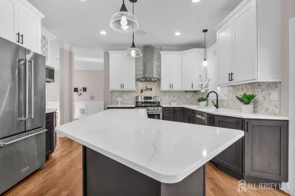 a kitchen with stainless steel appliances granite countertop a refrigerator a stove and a wooden floors