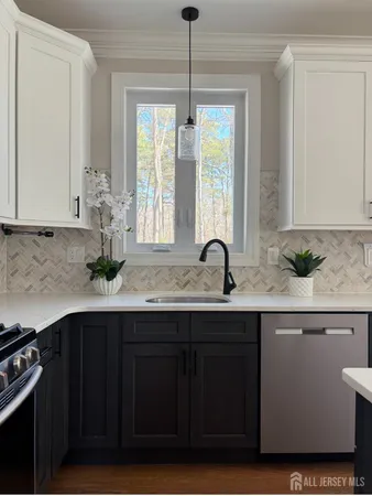 a view of kitchen with stainless steel appliances wooden floor and wooden cabinets