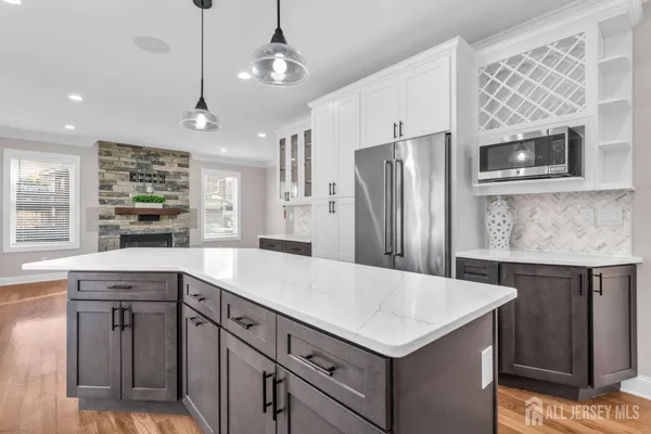 an empty room with windows fireplace and wooden floor