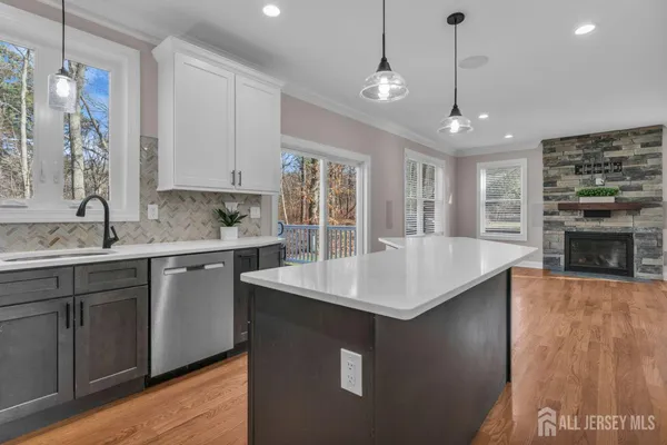 a kitchen with kitchen island a counter top space a sink stainless steel appliances and cabinets
