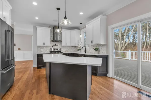 a large kitchen with stainless steel appliances granite countertop a stove a sink dishwasher and a refrigerator with wooden floor