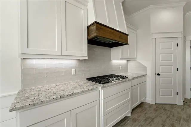 a kitchen with white cabinets and appliances