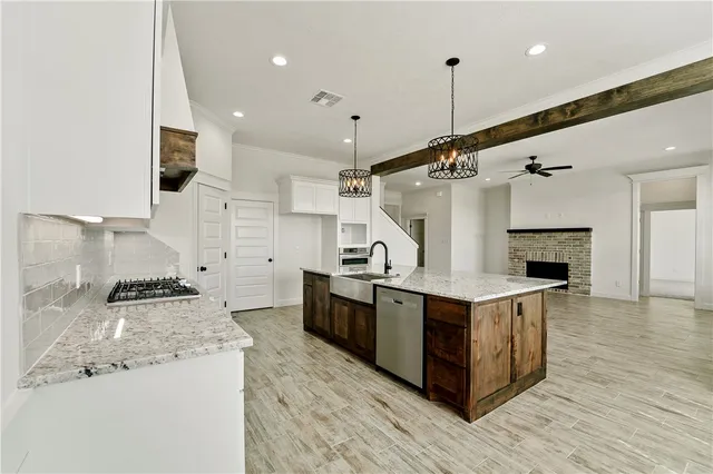 a kitchen with stainless steel appliances granite countertop a sink and a stove
