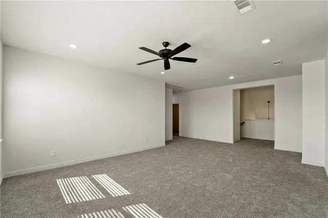 an empty room with a ceiling fan and a window